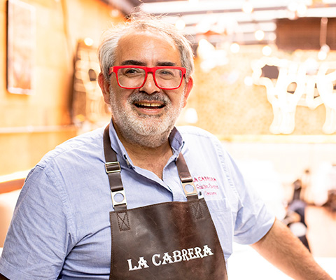El chef Gastón Riveira, fundador de La Cabrera, con su delantal en la parrilla
